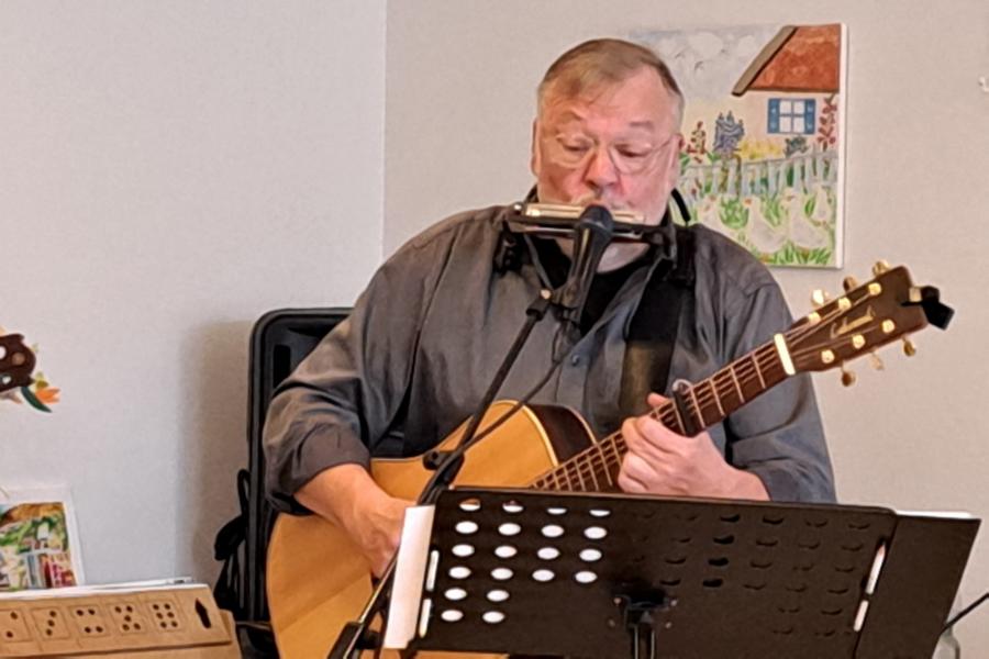 Helmut Deseniß mit Gitarre und Mundharmonika