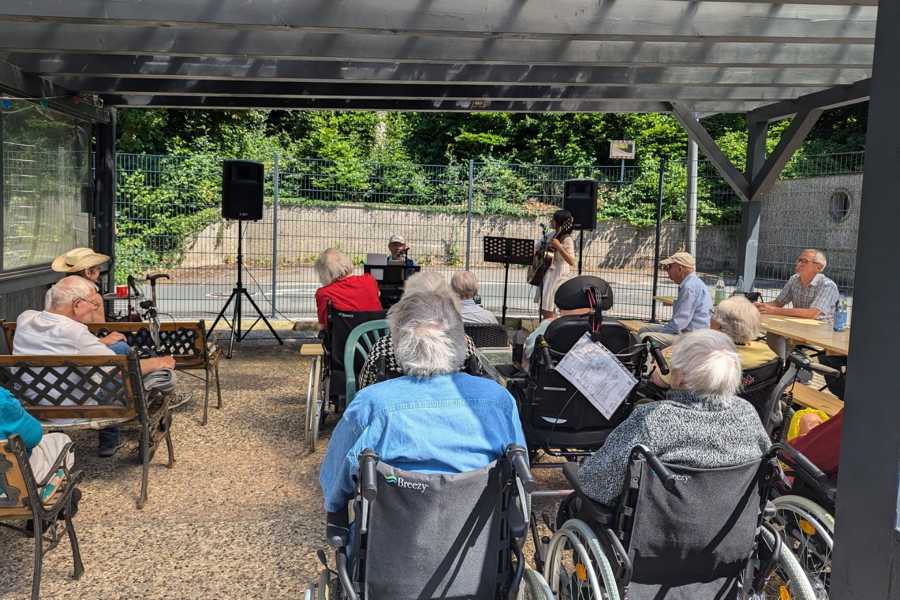 Aufmerksames Publikum im gemütlichen Garten des Seniorenheims