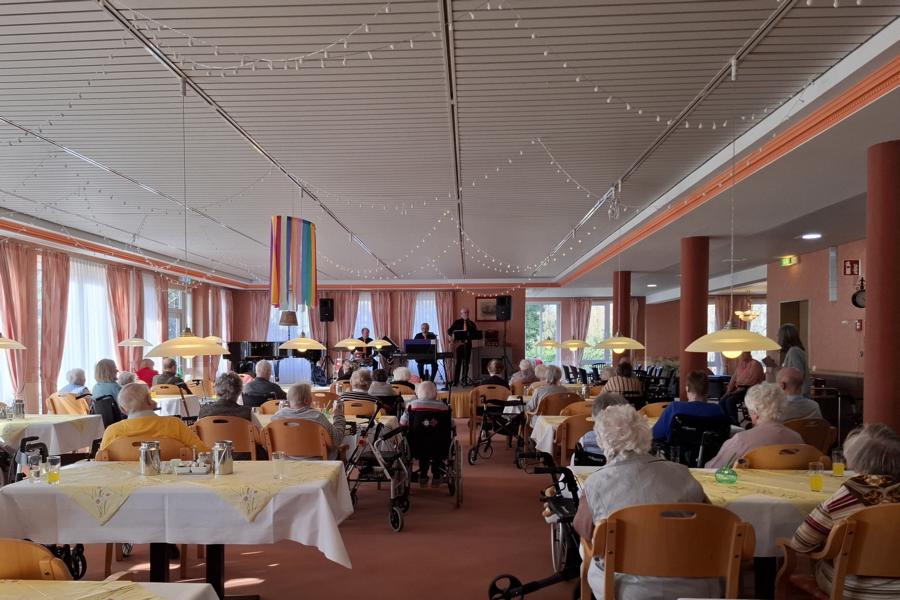 Begeisterte Seniorinnen und Senioren genießen die Musik im schönen Ambiente des großen Saals.