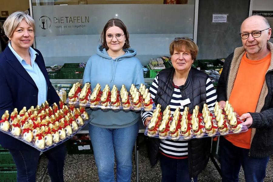 Antrud Schröder (links) und Detlef Hüper überreichen die Osterhasen an Tafelleiterin Elisabeth Bekiersch und Helferin Hannah Knye